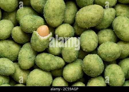 Hintergrund von mit Wasabi beschichteten Erdnüssen. Sichtbare Erdnuss und Kruste. Draufsicht. Stockfoto