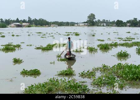 Morigaon, Assam, Indien. Juli 2020. Dorfbewohner überqueren ein überflutetes Gebiet auf einem Boot, im Dorf Buraburi im Morigaon Bezirk von Assam. Kredit: David Talukdar/ZUMA Wire/Alamy Live Nachrichten Stockfoto