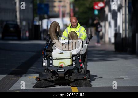 Ein Straßenreiniger bei der Arbeit während der Coronavirus-Sperrzeit in Cardiff, Wales, Großbritannien. Stockfoto