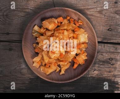 Geschmorter Kohl mit Huhn auf einem Holzteller. Draufsicht Stockfoto