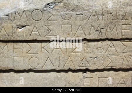 Griechenland, Athen, Juni 18 2020 - Inschrift auf altem Marmor an der archäologischen Stätte von Akropolis Hügel. Stockfoto