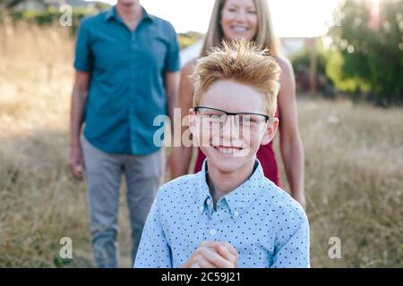 Der Rothaarige Junge Schillert, Während Er Eine Übergroße Brille Trägt Stockfoto