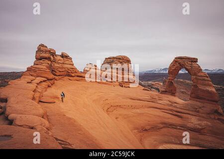 Ein Mann mit einem Kind steht in der Nähe eines zarten Bogens Am Arches NP Stockfoto