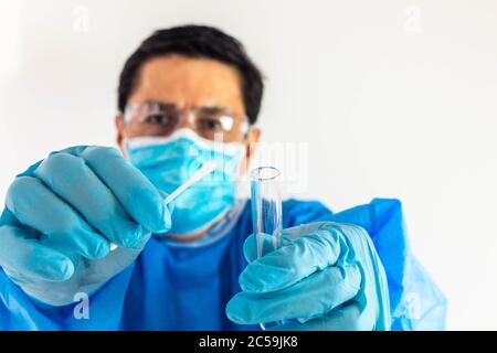 Subjektive Aufnahme eines Arztes, der einen Tupfer und ein Reagenzglas zur Nase eines Patienten bringt, um eine Probe für eine medizinische Untersuchung zu nehmen. Coronavirus. Selektiver Fokus Stockfoto