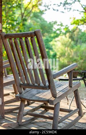 Schaukelstuhl auf der Veranda der Blockhütte Stockfoto