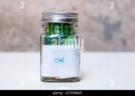 Zusammensetzung mit Geld sparen Banknoten in einem Glas mit Text New Car .Concept der Investition und Geld halten, nah an isoliert. Stockfoto