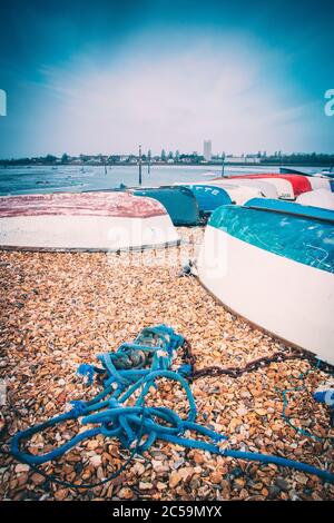 Umgedrehte hölzerne Fischerboote auf einem Kiesstrand am Ufer Stockfoto