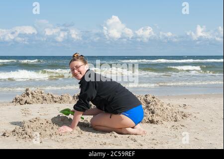 Mutter baute Sandburg am Strand in Mrzezyno, Woiwodschaft Westpommern, Polen Stockfoto