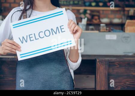 Willkommen! Kleines Unternehmen: Glücklicher Besitzer eines Cafés. Junge Startup-Besitzer kleines Café-Shop. Stockfoto