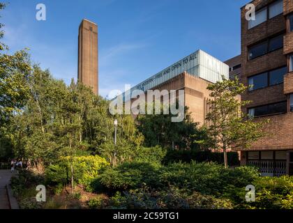 Schräge Ansicht durch Bäume auf der Nordseite. Tate Modern, London, Großbritannien. Architekt: Sir Giles Gilbert Scott, Herzog de Meuron, 2000. Stockfoto