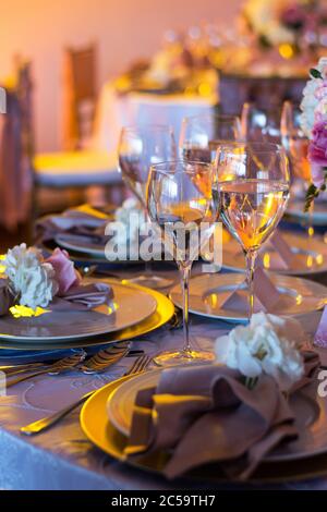 Gläser Wein und Teller in einem eleganten und formellen Abendessen der Hochzeit. Stockfoto