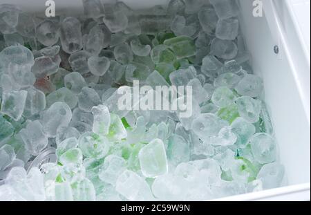 Nahaufnahme von Trinkdosen in Eisblöcken im Kühler Stockfoto