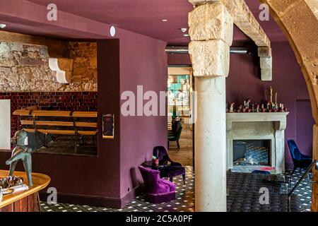 Pudelbar im Hotel Rathof, Kassel, Deutschland. Ein Blick in die Tiefe: Wer ins Restaurant oder in die Bar will, kommt durch die Lounge in Stimmung. Eine gewagte Mischung aus Farben, Möbeln und Fliesen, immer mit dem Charme des alten Steins als Kontrast Stockfoto