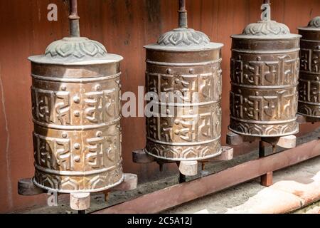 Gebetsräder entlang des äußeren Umfangs des buddhistischen Balkumari-Tempels, Thimi Stockfoto