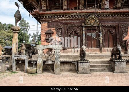 Steinelefanten und eine heilige Glocke, die auf einer Seite des Changu Narayan-Tempels, Kathmandu Valley, Nepal, Stockfoto