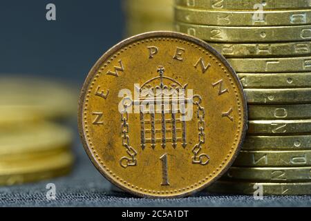 Eine alte, 1980 Jahre alte, eine Penny Münze, die vor den Haufen Münzen auf den Rand gelegt wird Stockfoto