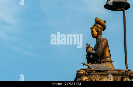 Oben auf einer Säule ragt die Bronzestatue von König Bupathindra Malla, dem Gründer von Bhaktapur, am Himmel des Durbar Square in Bhaktapur, Nepal, hervor Stockfoto