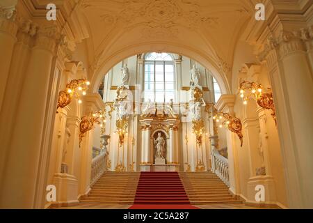 Wunderschön dekorierte Innenausstattung mit Gold- und rotem Teppich. Unterer Teil der Jordan Treppe, Winterpalast, Staatliche Eremitage Museum, St. Petersburg, Russland. Stockfoto