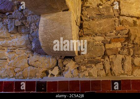 Eine kleine weiße Pudel-Silhouette an der Wand markiert eine Ecke des gewölbten Naturstein-Kellers im Hotel Renthof in Kassel, Hessen, Deutschland, einem ehemaligen Karmeliterkloster aus dem Jahr 1298, das im Juni 2017 als Hotel, Restaurant und Veranstaltungsort wiedereröffnet wurde, zeitgleich mit documenta 14. Grob behauener Bruchsteinmauerwerk und ein Kreuzgewölbe verraten die historische Substanz des Gebäudes, wobei dunkelrote Ziegel die Basis der Wand säumen. Stockfoto