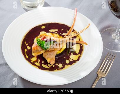 Gebratenes hammelfleisch Rippen mit gebackenen Auberginen und Wein Sauce serviert. Stockfoto