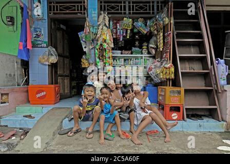 jakarta, dki jakarta/indonesien - 16. november 2009: Kinder vor einem Lebensmittelgeschäft in einem armen Wohnviertel auf jalan slamet riyadi 4 in Kampung Stockfoto