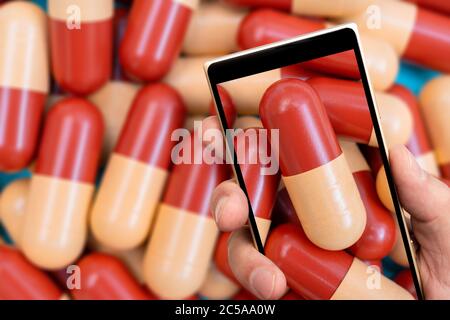 Medikamentenkapseln auf dem Smartphone-Bildschirm. Pharmazeutische Droge ist Medizin für Behandlung. Stockfoto