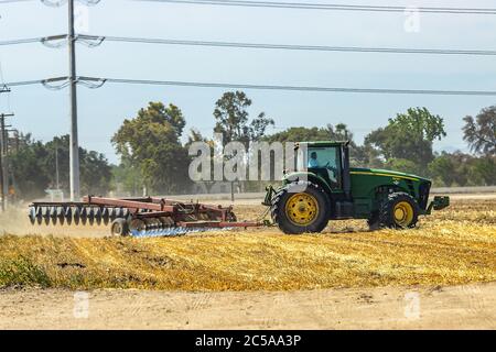 Ein John Deere Traktor, der ein Feld im Stanislaus County im Central Valley von Kalifornien USA ausscheide Stockfoto