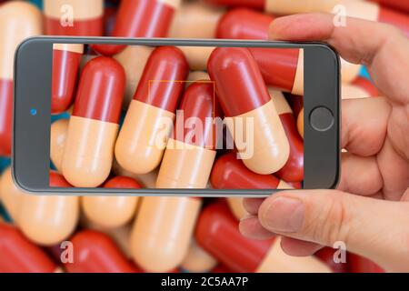 Medikamente Pillen oder Kapseln auf dem Smartphone-Bildschirm. Medizinische Verschreibung für die medikamentöse Behandlung. Pharmazeutische Droge, Medizin in Behälter für Gesundheit. Sal Stockfoto