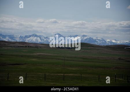 Scharfe Bergspitzen mit Schnee bedeckt und unter dem schimmernden wolkiger Himmel Stockfoto