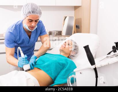 Junge Frau, die professionelle Ultraschall rf Lifting Verfahren in der Beauty-Klinik Stockfoto