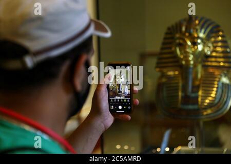 Kairo, Ägypten. Juli 2020. Ein Mann fotografiert am 1. Juli 2020 die goldene Maske von König Tutanchamun im Ägyptischen Museum in Kairo, Ägypten. Ägypten hat am Mittwoch das Ägyptische Museum, die Pyramiden von Gizeh und den Luxor-Tempel zum ersten Mal seit der Schließung von COVID-19 im März wiedereröffnet. Quelle: Ahmed Gomaa/Xinhua/Alamy Live News Stockfoto