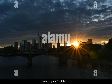 01. Juli 2020, Hessen, Frankfurt/Main: Die Sonne geht abends hinter der Skyline der Bankenstadt unter. Foto: Arne Dedert/dpa Stockfoto