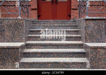 Granittreppe mit einem Aufstieg zur Haustür, Schwelle mit Treppeneingang Nahaufnahme Vorderansicht. Stockfoto