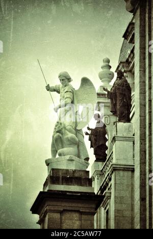 Skulpturengruppe - Engel tötet den Teufel auf der neugotischen Kirche Santa Maria la Real de La Almudena - berühmte Kathedrale in Madrid, Spanien. Gefiltert Stockfoto