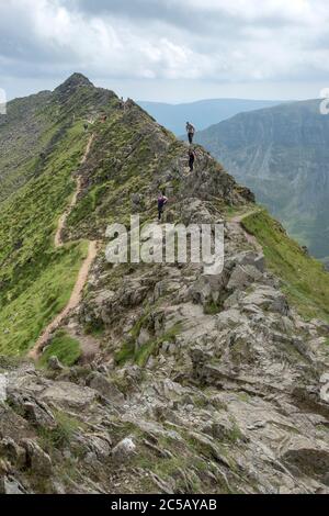 Wanderer kriechen über Felsen auf dem Grat der stierenden Kante im Seengebiet Stockfoto