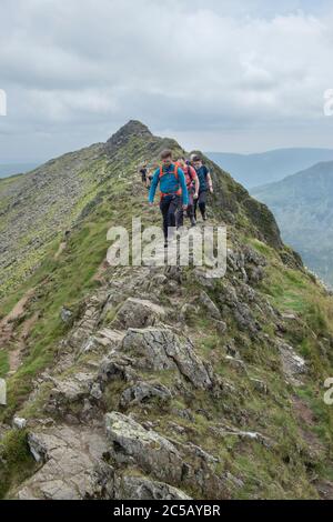 Wanderer kriechen über Felsen auf dem Grat der stierenden Kante im Seengebiet Stockfoto