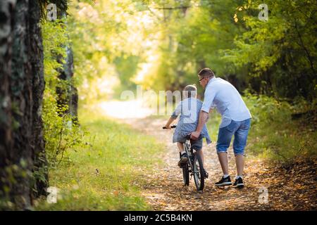 Vater lehrt Sohn Fahrrad zu fahren Stockfoto