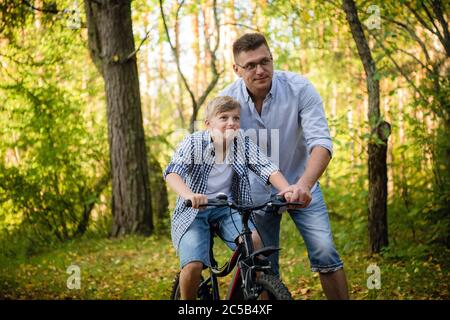 Vater lehrt Sohn Fahrrad zu fahren Stockfoto