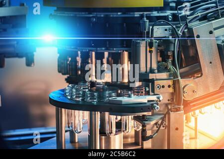 Industrielle automatisierte Maschine zum Blasen von Kunststoffflaschen aus PET-Preforms, close up. Stockfoto