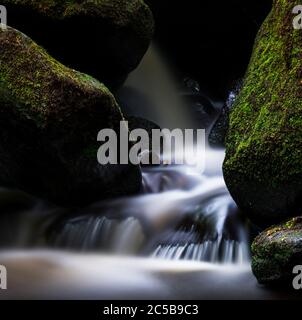 Langzeitaufnahme eines kleinen Wasserfalls am Fluss bei Padley Gorge im Peak District, Derbyshire, England. Stockfoto