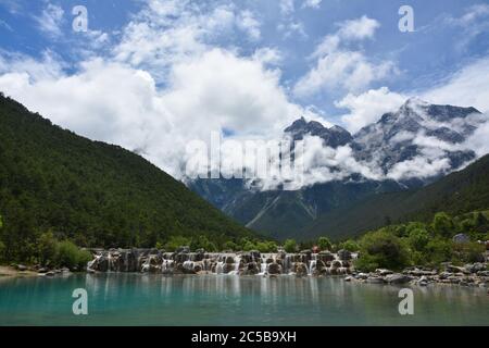 Wasserfall am Fuße der Berge bei sonnigem Tag Stockfoto