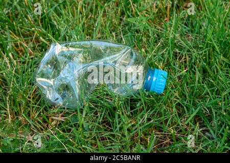 Eine Plastikflasche liegt im Gras. Konzept der Umweltverschmutzung. Stockfoto