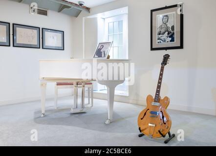 Raum mit dem berühmten weißen Klavier, das früher Imagine spielte, und einer Gitarre von John Lennon bei der Beatles Story Ausstellung in Liverpool Stockfoto