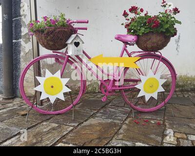 Schöne dekorative alte Fahrrad mit Blumen in Töpfen Stockfoto