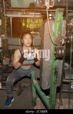 Junge asiatische Mädchen Fitness ausführen Übung mit Übung-Maschine im Fitnessstudio. Stockfoto