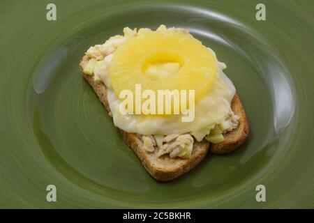 Offenes Thunfisch-Salat-Sandwich mit geschmolzener Provolone-Käsescheibe und Ananasfruchtring Stockfoto