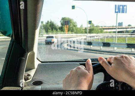 Auto Austausch Seitenansicht eines Fahrers eines Autos, auf dem Lenkrad nicht gut gepflegte Hände einer Frau mittleren Alters Stockfoto