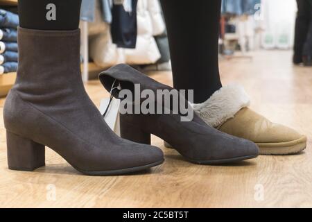 Junge Frau, die versucht auf Schuhe im shop Stockfoto