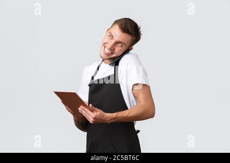 Einzelhandelsgeschäfte, kleine Unternehmen, Cafés und Restaurants Takeaway Konzept. Schöner junger Ladenmanager, Angestellte, der telefonisch bestellt wurde, und mit dem er sprach Stockfoto