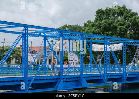 New Orleans, LA/USA - 27. Juni 2020: Magnolia Brücke über Bayou St. John mit Black Lives Matter Zeichen und Familie vorbei Stockfoto